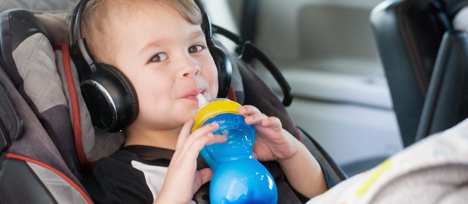 toddler drinking from Nuby cup in car